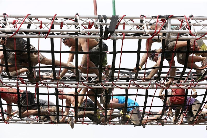 Competitors navigate their way through a rope obstacle.