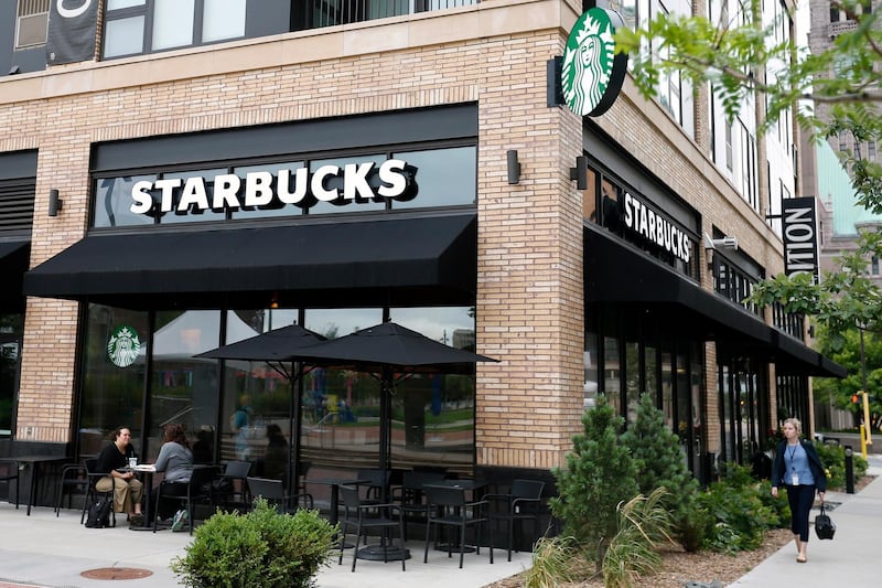 In this July 10, 2019, photo customers visit at a Starbucks in Minneapolis. Starbucks Corp. reports financial earnings on Thursday, July 25, 2019. (AP Photo/Jim Mone)