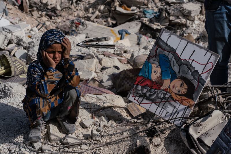 A child sits amid rubble in the city of Jindires following the earthquake near Aleppo, Syria. Getty Images