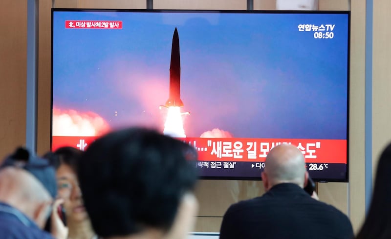 People watch a TV showing a file image of a North Korea's missile launch during a news program at the Seoul Railway Station in Seoul, South Korea, Tuesday, Aug. 6, 2019. North Korea on Tuesday continued to ramp up its weapons demonstrations by firing unidentified projectiles twice into the sea while lashing out at the United States and South Korea for continuing their joint military exercises that the North says could derail fragile nuclear diplomacy. The sign reads "North Korea could seek a new road." (AP Photo/Ahn Young-joon)
