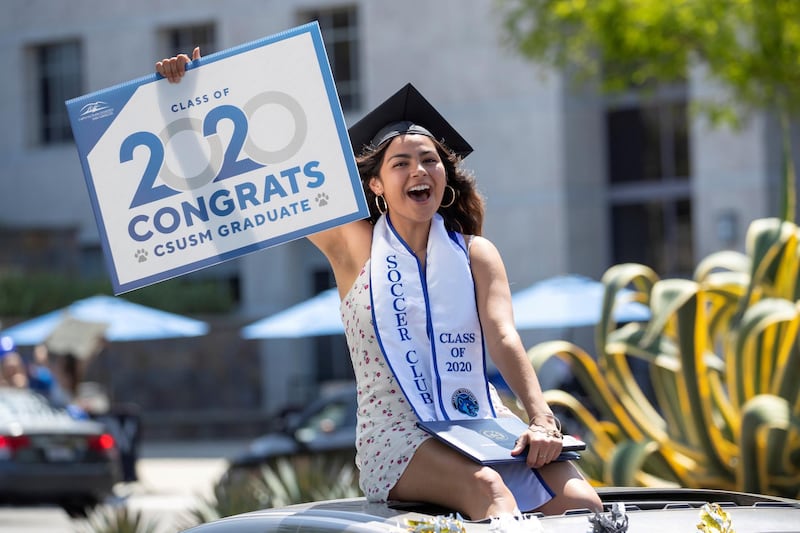 A US graduate from California State University San Marcos celebrates while participating in a car parade through campus. Reuters