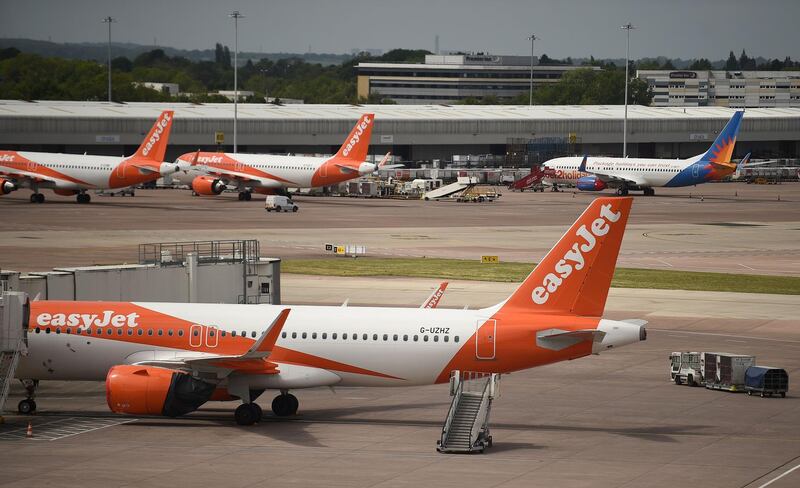 (FILES) In this file photo taken on May 11, 2020 Easyjet aircraft stand on the apron the departure gates at Manchester Airport in Manchester, northern England where they have begun a trial of body temperature screening during the COVID-19 pandemic. British no-frills airline EasyJet said on May 28, 2020, that it will axe up to 4,500 jobs, or 30 percent of its workforce, as coronavirus ravages demand and grounds planes worldwide. 
 / AFP / Oli SCARFF                          

