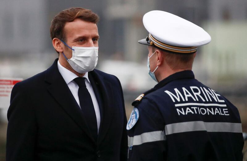 French President Emmanuel Macron speaks with a French Navy officer as he arrives at the French frigate Bretagne as part of his presentation of New Year wishes to the military forces in Brest, on January 19, 2021.  / AFP / POOL / STEPHANE MAHE
