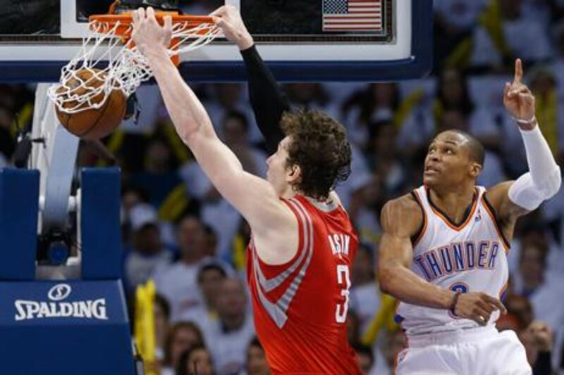Houston Rockets' Omer Asik dunks in front of Oklahoma City Thunder's Russell Westbrook.