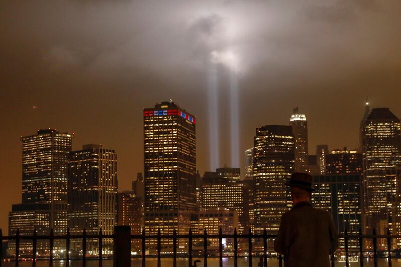 A man looks at the Tribute in Light installation as it illuminates over lower Manhattan as seen from the borough of Brooklyn. Reuters