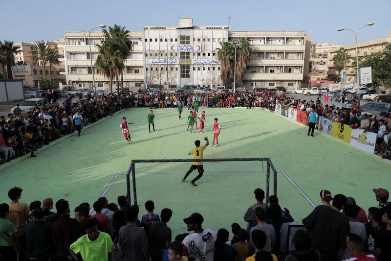 Neighbours gather to watch as boys play football during Ramadan in Benghazi, Libya. Reuters