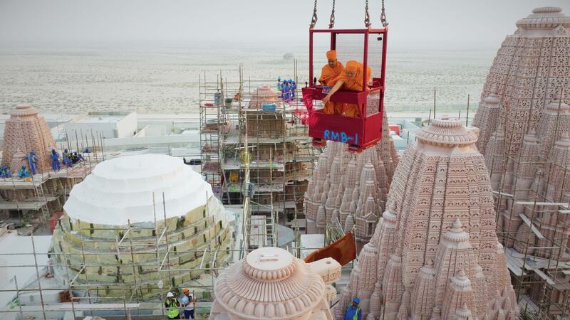 Ishwarcharan Swami performs prayers above the Hindu temple from a crane. BAPS Hindu Mandir