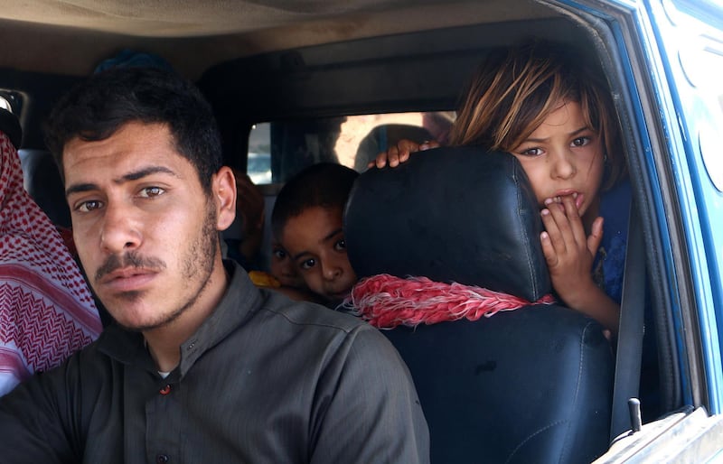 A Syrian family rides in a vehicle as they head to safer areas in the northern part of Syria's rebel-held Idlib province on September 6, 2018. - Hundreds of civilians have fled villages near the front line in Syria's Idlib province fearing an imminent regime assault on the country's last major rebel bastion, a monitor said. (Photo by Aaref WATAD / AFP)