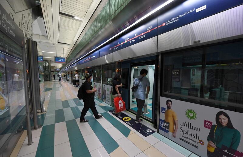 Passengers adhere to social distancing as they enter a train on the Dubai Metro. AFP