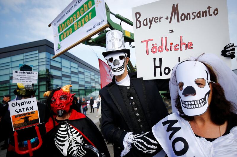 People protest against the merger of Germany's pharmaceutical and chemical maker Bayer with U.S. seeds and agrochemicals company Monsanto, before Bayer's annual general shareholders meeting in Bonn, Germany. REUTERS / Wolfgang Rattay