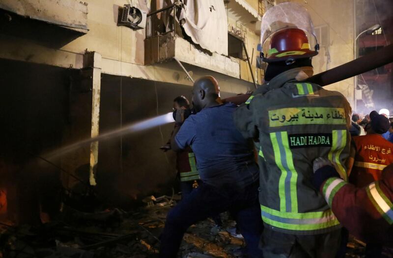 Firefighters spray water at the site of a fuel tank explosion in the al-Tariq al-Jadida neighborhood of Beirut, Lebanon. REUTERS