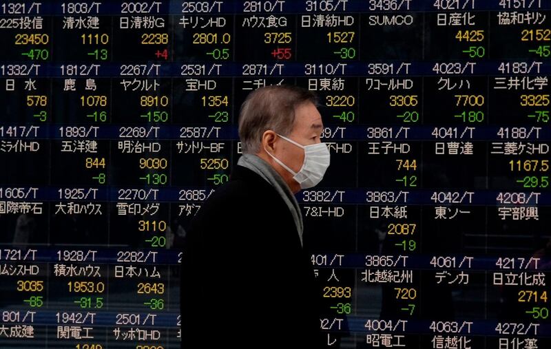 TOPSHOT - A man walks past an electronics stock indicator shows stocks on the Tokyo Stock Exchange in Tokyo on February 5, 2018.
Tokyo stocks opened lower on February 5, tracking drops on Wall Street, as investors kept close watch for several corporate earnings results in Japan. / AFP PHOTO / Kazuhiro NOGI