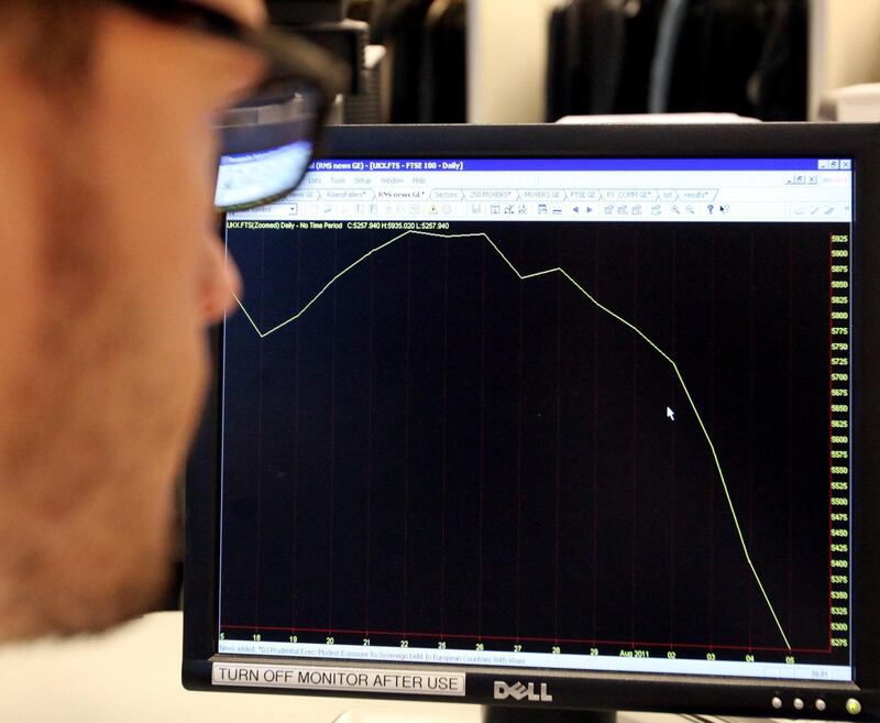 A worker looks at a graph showing the FTSE 100 index from mid July to August 5, 2011, as London's leading shares index sustained more heavy losses in early trading Friday Aug. 5, 2011,  as the turmoil engulfing world markets showed no signs of easing. Global stock markets tumbled Friday amid fears the U.S. may be heading back into recession and Europe's worsening debt crisis, following the biggest one-day points decline on Wall Street since the 2008 financial crisis. (AP Photo / Katie Collins, PA) UNITED KINGDOM OUT - NO SALES - NO ARCHIVE *** Local Caption ***  Britain World Markets.JPEG-0158c.jpg