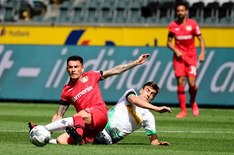 Leverkusen midfielder Charles Mariano Aranguiz, left, and Moenchengladbach midfielder Florian Neuhaus vie for the ball. AP