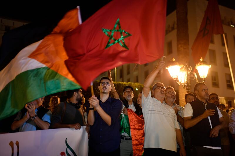 Protesters wave Palestinian and Moroccan flags as they gather in front of Parliament Square in Rabat, Morocco. EPA