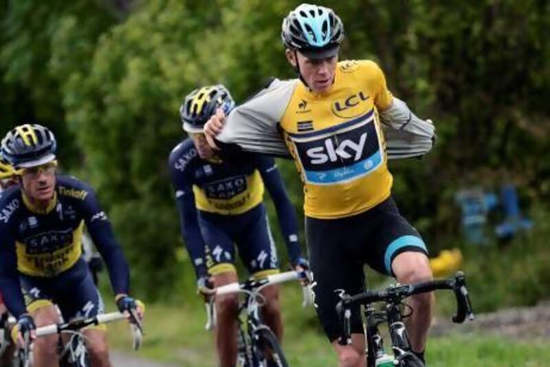 Britain's Christopher Froome removes his raincoat as he rides during the 155.5-kilometre final stage of the 65th edition of the Dauphine Criterium.
