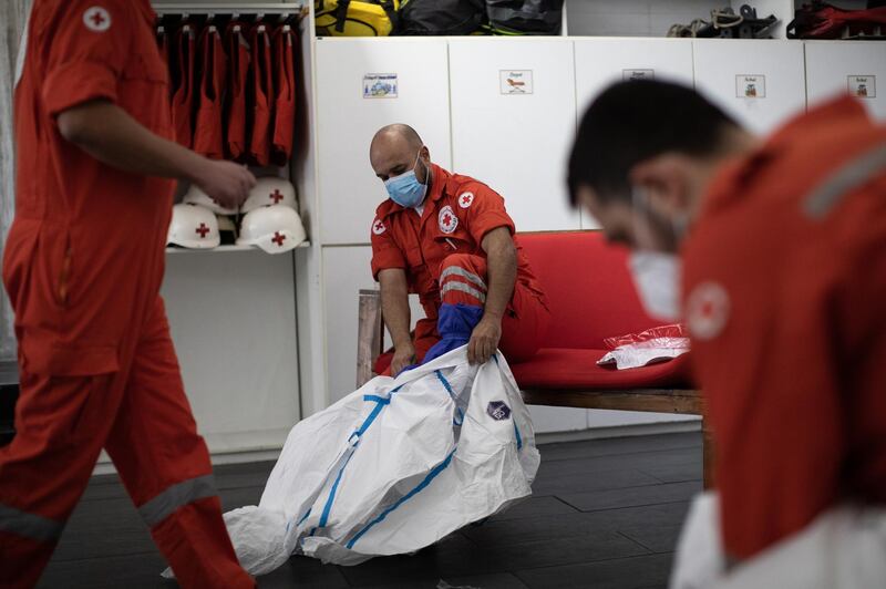 ©2021 Tom Nicholson. 23/01/2021. Jounieh, Lebanon. Lebanese Red Cross volunteer paramedic David ÒAbboutÓ Ayache (centre) puts on Coronavirus PPE at Jounieh station. DavidÕs nickname means ÒgrasshopperÓ, and his day job is working as an internet provider. Today Lebanon registered 4176 new Coronavirus cases, and 52 deaths. Tom Nicholson for The National