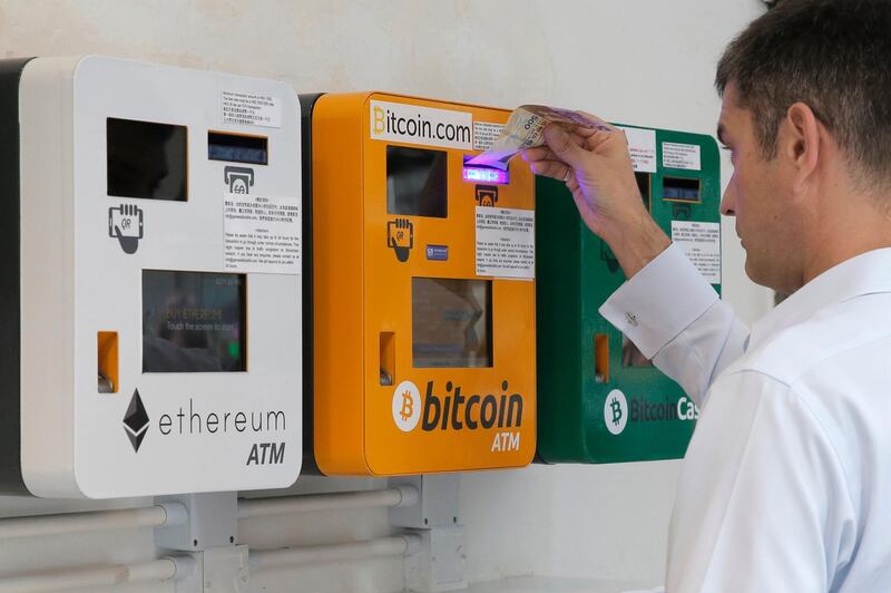 A man uses the Bitcoin ATM in Hong Kong, Friday, May 11, 2018. Bitcoin is the world's most popular virtual currency. Such currencies are not tied to a bank or government and allow users to spend money anonymously. (AP Photo/Kin Cheung)