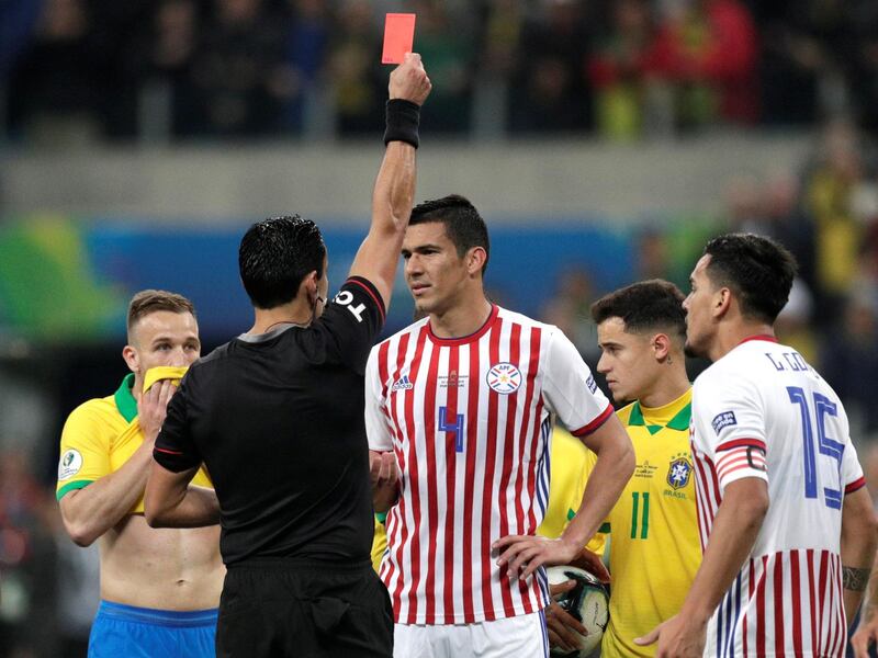 Paraguay's Fabian Balbuena is shown a red card by referee Roberto Tobar. Reuters