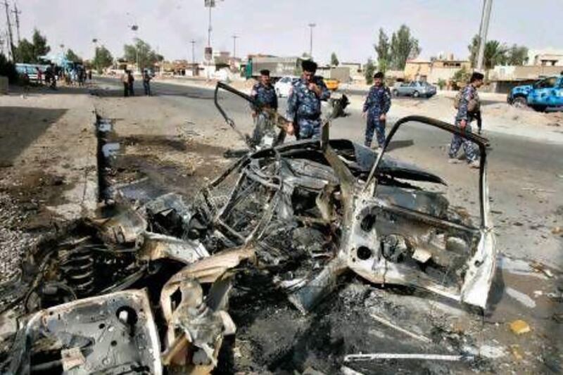 Security personnel inspect the site of a car bomb attack in Kirkuk, 250km north of Baghdad. Two car bombs went off simultaneously in the ethnically mixed city, killing three people and wounding 10 others.