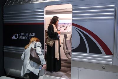 Visitors try out the seats on an Etihad Rail display. Victor Besa / The National