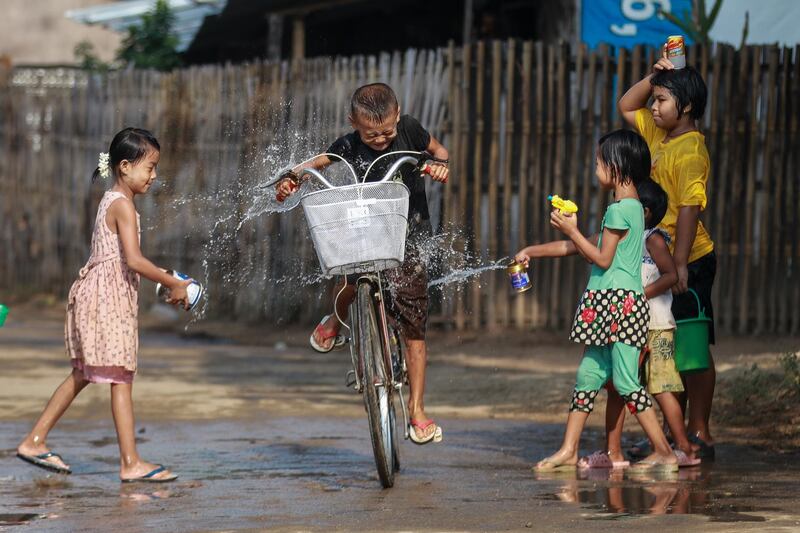 Children douse a child on a bicycle with water to mark the Thingyan Water Festival at Naypyitaw, Myanmar. EPA