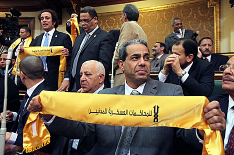 A new Egyptian MP holds a scarf reading "No to military trials for civilians" during the opening of parliament in Cairo yesterday.