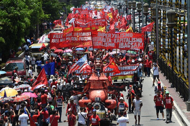 Thousands of workers waving banners and placards march as they pull a carriage with an effigy representing Philippine President Rodrigo Duterte during a demonstration marking Labour Day in Manila.  AFP