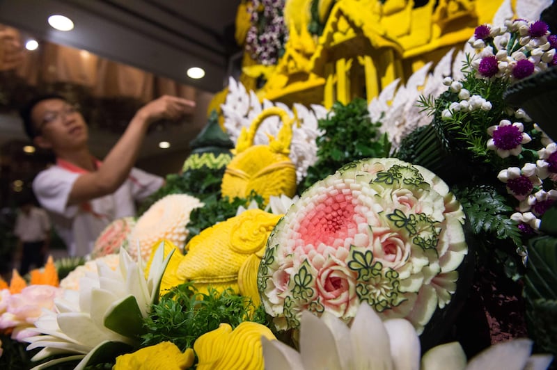 A Thai man helps put together an elaborate decoration display with carved fruits and vegetables during a fruit and vegetable carving competition in Bangkok. Robert Schmidt / AFP