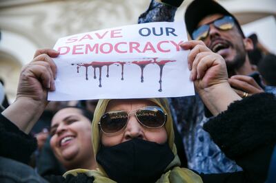 A woman holds up a banner during a protest against Tunisian President Kais Saied, in Tunis. AP