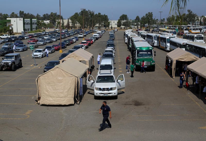 Cars and buses from maquiladoras line up for people to receive the Johnson & Johnson vaccine as part of a government plan to inoculate Mexican border residents on its shared frontier with the United States, in Tijuana, Mexico. Reuters