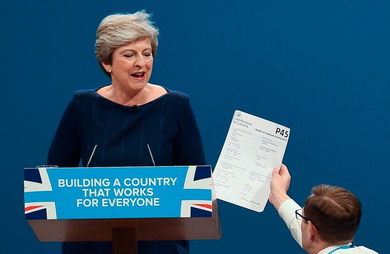 Comedian Simon Brodkin, right, givesBritain's Prime Minister Theresa May her P45 (UK's employee leaving form) during the Conservative Party annual conference in Manchester. Paul Ellis / AFP Photo / October 4, 2017