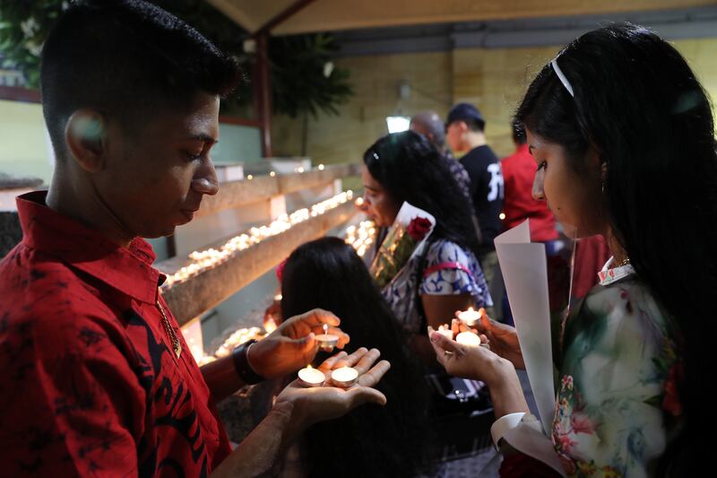 People lighting the candles during the Christmas midnight mass held at St. Mary's Catholic Church in Dubai. Pawan Singh / The National