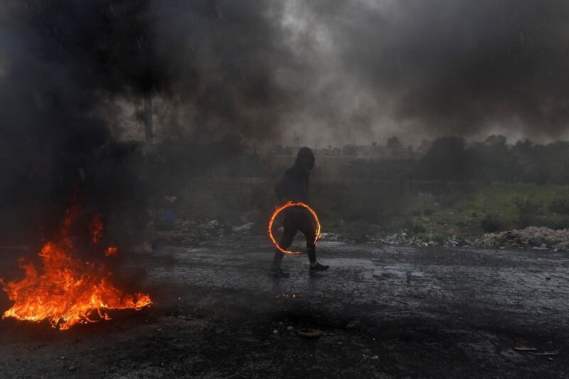 A Palestinian demonstrator holds a ring of fire during clashes with Israeli forces at a protest marking Land Day, near the Jewish settlement of Beit El, in the Israeli-occupied West Bank. Reuters