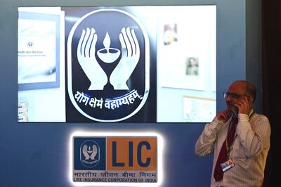 A man speaks on his mobile phone next to an LIC sign. The life insurer is household name in India. AFP
