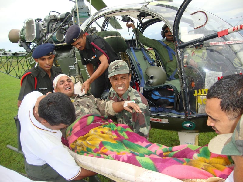 Indian army personel evacuate injured army personel from north Sikkim, Peygang village, some 70 kms from Gangtok, on September 20, 2011, after a 6.9-magnitude earthquake hit the region on September 18. Rescue teams backed by army sappers using explosives tried to force their way to the remote epicentre of a powerful Himalayan earthquake that killed 67 people in India, Nepal and Tibet. Before the grim search for more victims can even begin, the main challenge is to reach the isolated, mountainous impact zone on the border between India's northeastern Sikkim state and Nepal after the quake. AFP PHOTO/STR
 *** Local Caption ***  874191-01-08.jpg