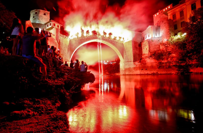 A man jumps holding torches from the Old Bridge in Mostar, Bosnia, during a night show of high diving skills that ended an annual diving competition more than 4.5 centuries old. More than 10,000 spectators converged on the southern Bosnian city at the weekend to watch 41 daring men take a jump from the 27-meter-high historic Old Bridge into the cold, fast-flowing Neretva River below. Amel Emric.