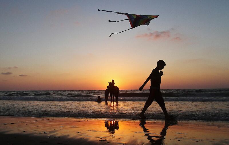 epa03298568 A Palestinian child flies a kite at Shaik Ajlen beach in the Gaza Strip, on 06 July 2012  EPA/ALI ALI