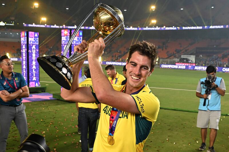 Australia captain Pat Cummins poses with the trophy . AFP