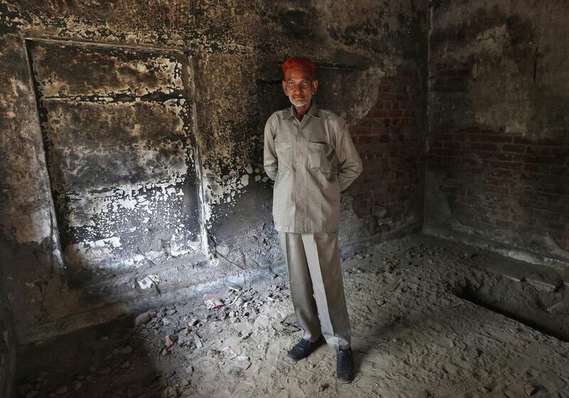 Sayeed Khan Pathan, a Muslim, poses inside his house which was burnt and damaged in the Gujarat 2002 riots at the Gulbarg Society, a Muslim-dominated housing, in the western Indian city of Ahmedabad.