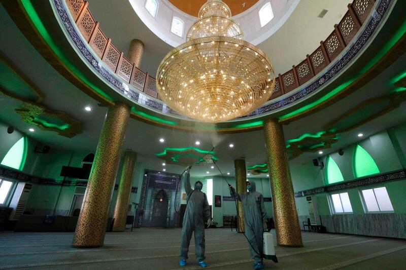 Palestinians disinfect a mosque in the occupied West Bank city of Hebron during Eid Al Fitr. AFP