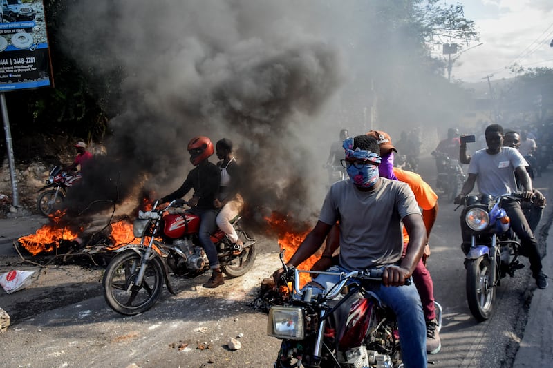 Motorcyclists join protests against Prime Minister Ariel Henry’s rule in Port-au-Prince, Haiti, as rubbish burns in the streets. EPA