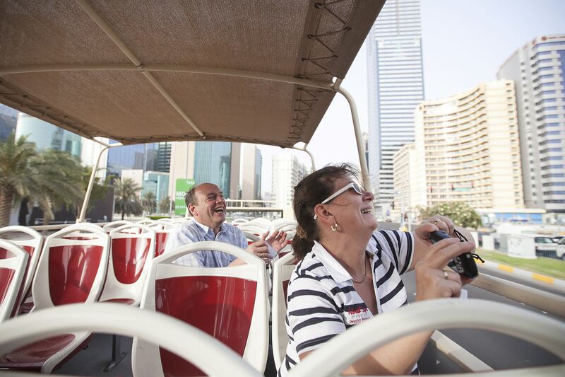 German tourists Joerg Lippert, 51, and his wife Ingert enjoy the ride aboard the Big Bus tour. The buses take passengers to 22 locations around Abu Dhabi. Mona Al Marzooqi / The National