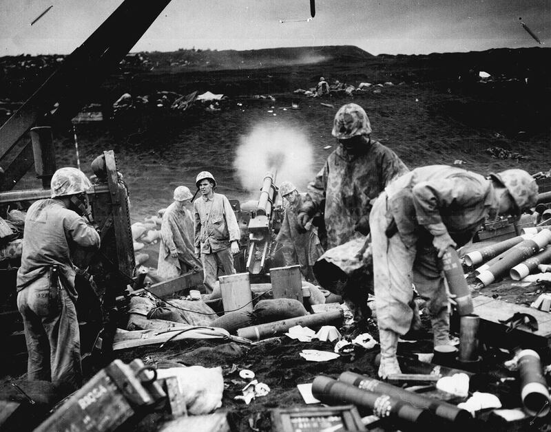 US marines with the Fourth Division fire on enemy positions from the black sands of an Iwo Jima beach, on February 1945. Reuters