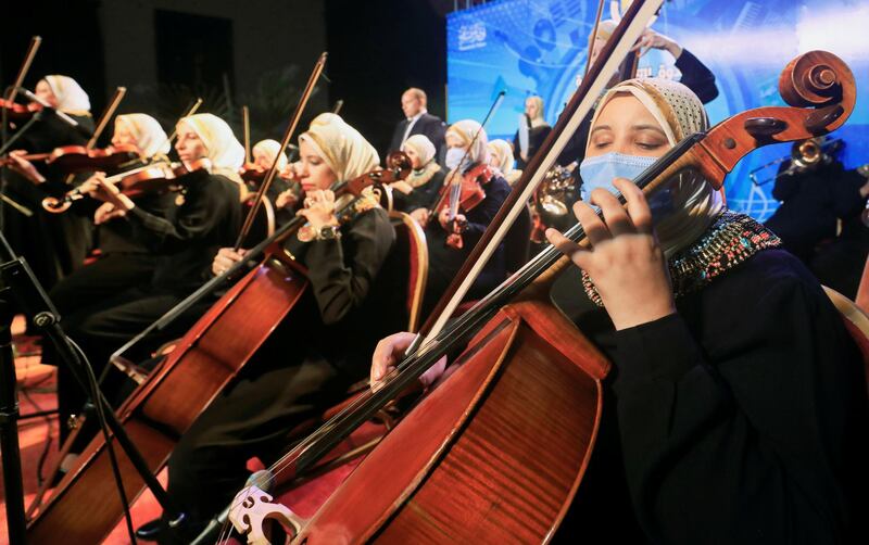 A member of Al Nour Wal Amal (Light and Hope) chamber orchestra for blind women wears a protective mask as she plays during the first concert at the Manasterly Palace in Cairo, Egypt. Reuters