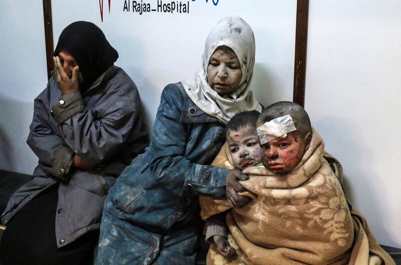 In this photo taken on February 20, 2017, a Syrian woman sits with injured children at a hospital following a reported strike by government forces in the rebel-held district of Barzah, on the north-eastern outskirts of the capital Damascus. AFP