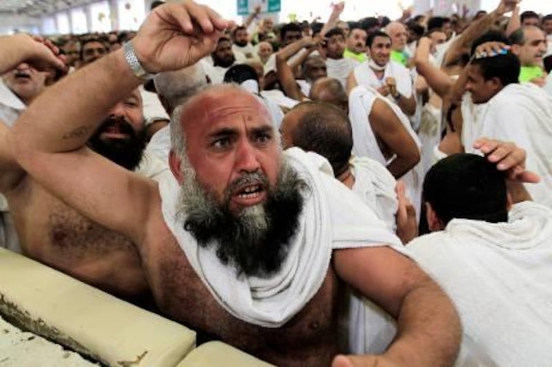 Muslim pilgrims cast stones at a pillar, symbolizing the stoning of Satan, in a ritual called "Jamarat," the last rite of the annual hajj, in Mina near the Saudi holy city of Mecca, Saudi Arabia, Sunday, Nov. 6, 2011. The annual Islamic pilgrimage draws 2.5 million visitors each year, making it the largest yearly gathering of people in the world. (AP Photo/Hassan Ammar) *** Local Caption ***  Mideast Saudi Arabia Hajj.JPEG-00bba.jpg