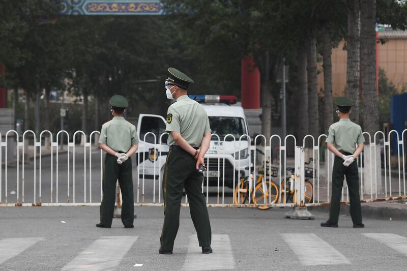 Paramilitary police officers stand guard at an entrance to the closed Xinfadi market in Beijing on June 13, 2020.  Eleven residential estates in south Beijing have been locked down due to a fresh cluster of coronavirus cases linked to the Xinfadi meat market, officials said on June 13. / AFP / GREG BAKER
