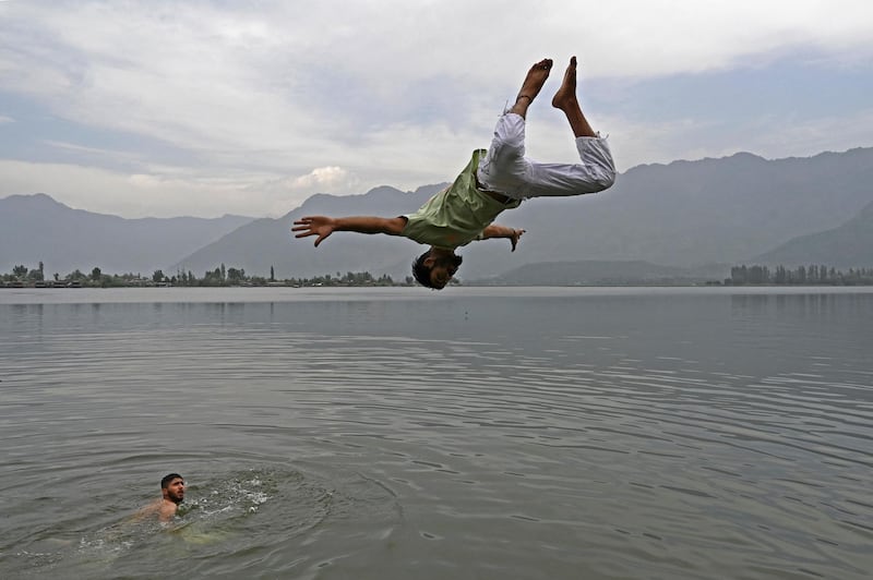 A boy jumps into the waters of Dal Lake on a hot summer day in Srinagar in India-administered Kashmir. AFP