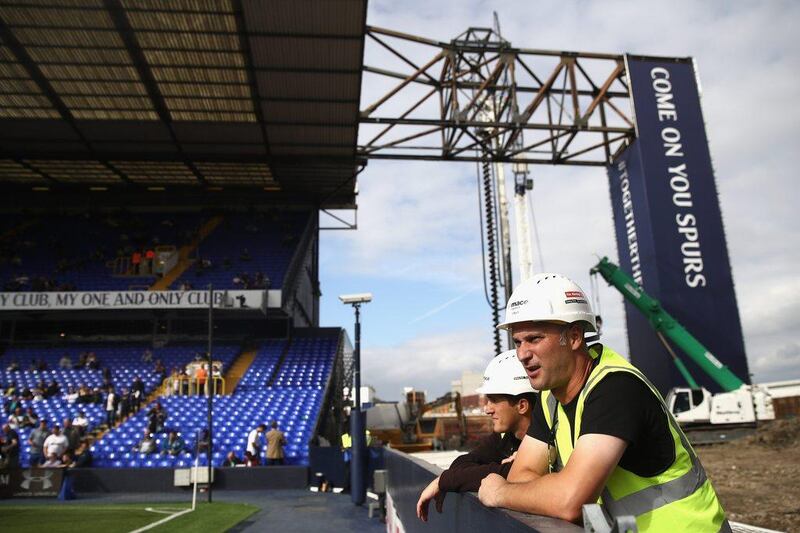 Two construction workers check out the pitch while having a break from work before the Premier League match between Tottenham Hotspur and Sunderland at White Hart Lane. Julian Finney / Getty Images
